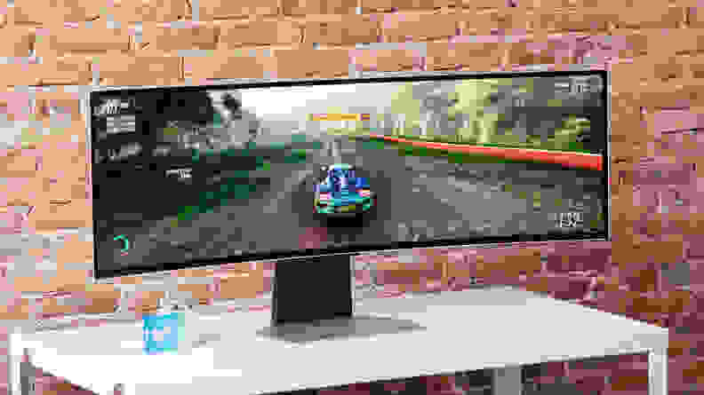 A super ultrawide monitor, the Samsung Odyssey OLED G9, with a racing game on screen
