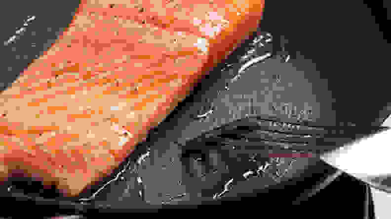 A close-up of a raw piece of salmon on the Circulon ScratchDefense Nonstick Frying Pan.