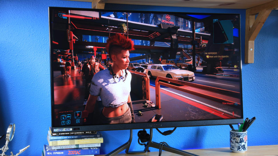 OLED gaming monitor featuring a video game on the screen with a blue background.
