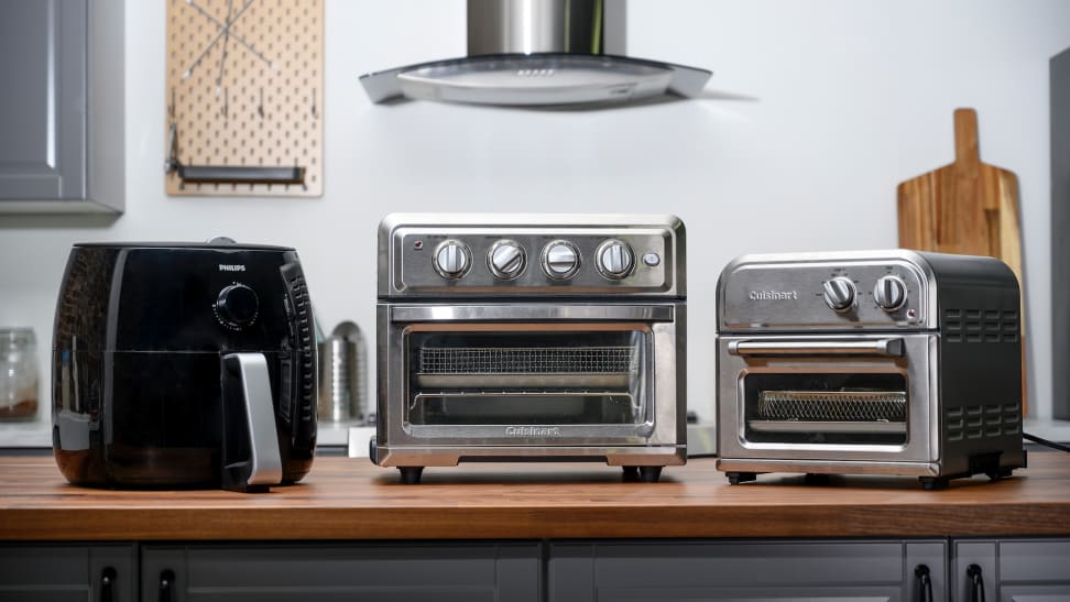 Basket Philips air fryer and Cuisinart air fryer toaster ovens lined up on a kitchen counter.