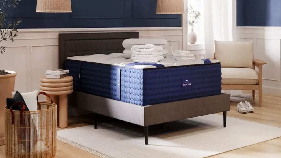 A DreamCloud mattress with bedding on top of it in a bedroom setup.