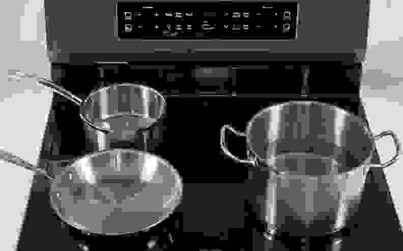 Three pieces of stainless steel cookware on induction cooktop