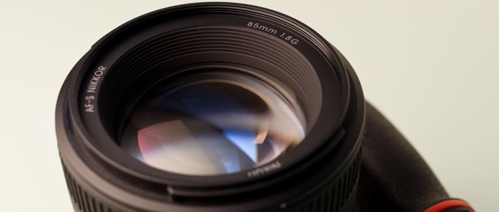 Close-up of a camera lens against a white-gray backdrop.