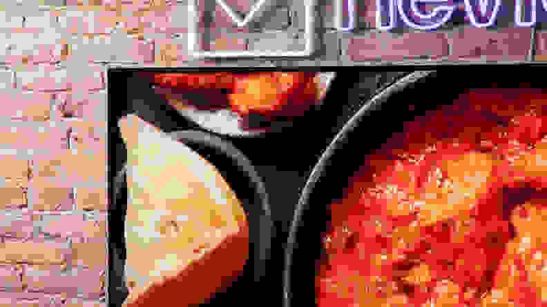 A TCL QM8 LED TV showing food being cooked onscreen with vibrant colors.
