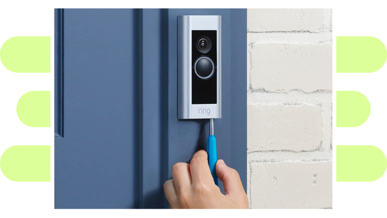 A hand inserting a wired connection to a video doorbell.