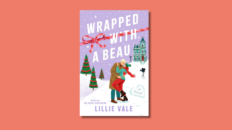 An image of the cover of 'Wrapped with a Beau' by Lillie Vale, featuring an image of a couple kissing in the snow in front of an old Victorian home.