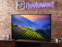 The Sony X90K LED TV displaying a nature scene with green, step hills and a blue and orange sunset.