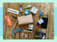 Small toiletry bag with assorted hygiene products scattered all around on tabletop surface.